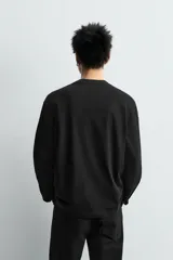 Camiseta de manga larga con corte relajado, confeccionada en algodón con acabado mercerizado y cuello redondo acabado en rib.