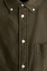 Camisa de algodón Oxford con cuello americano, tapeta clásica, bolsillo superior abierto y canesú en la espalda. Mangas largas con puños abotonados y bajo levemente redondeado.
