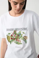 Remera blanca de algodón con cuello redondo y mangas cortas. Presenta una estampa botánica central con el texto 'DIARIO SILVESTRE' en tipografía clásica.