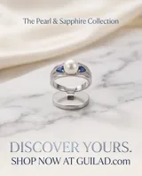 Anillo de plata 925 con una perla central y circonias azules y transparentes en los laterales.