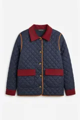 Campera capitoneada azul marino con diseño acolchado en rombos. Presenta detalles en pana color bordó en el cuello, puños y tapas de los bolsillos frontales. Cuenta con ribetes en color tostado, cierre frontal con botones y forro interior de polar.