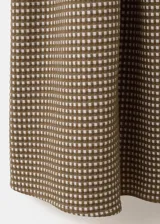 Vestido midi de corte evasé con estampado de cuadros vichy en tonos marrón y blanco. Presenta escote halter con tirantes finos para anudar al cuello, detalle fruncido en el centro del pecho y falda amplia de largo midi.