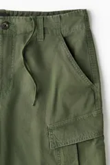 Bermuda cargo verde militar de ripstop de algodón, con bolsillos laterales con solapa, bolsillos al bies y corte holgado.