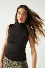 Top sin mangas de cuello alto, confeccionado en tejido liviano y suave con ajuste al cuerpo.