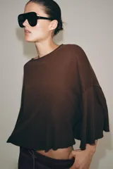 Camiseta de corte holgado confeccionada en una mezcla de algodón y lino, con cuello redondo y mangas tipo capa acampanadas.