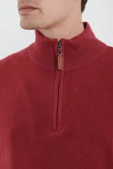 Sweater verde oliva de tejido acrílico con textura similar al cashmere, corte clásico, cuello alto con cierre metálico y tirador de cuerina ecológica.