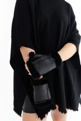 Poncho celeste de tejido de punto con cuello redondo y terminación desflecada.