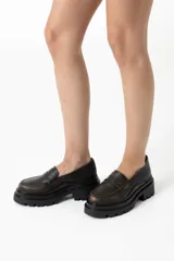 Mocasines de cuero marrón con suela track y detalle de antifaz.