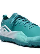 Championes Umbro modelo Vibe TF para hombre, color negro con efecto degradado a gris claro en la parte delantera. Presentan el logo Umbro en forma de diamante en el lateral y suela de goma con tacos bajos para césped artificial (turf).