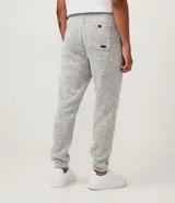 Pantalón de jogging gris jaspeado, con cintura elástica ajustable con cordón, bolsillos laterales y traseros, y puños ajustados.