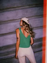 Blusa corta de tejido de punto con lurex y viscosa, color verde brillante, con escote en V y sin mangas.