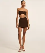 Short pollera color marrón chocolate, de crepé, con cintura fija y bolsillos delanteros.