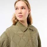 Chaqueta acolchada de color verde militar con diseño de rombos, cuello camisero y cierre frontal con botones a presión metálicos.