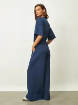 Pantalón azul oscuro de corte recto y tiro alto, con cintura elástica y bolsillos laterales.