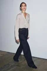 Jeans de tiro alto con corte wide leg y largo completo. Presenta diseño de cinco bolsillos, trabillas en la cintura y cierre frontal con cremallera y botón, con un acabado de efecto lavado.