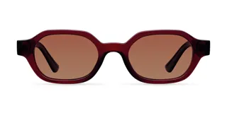 Lentes de sol de diseño retro con montura ovalada de color bordó y cristales polarizados en color marrón. Cuentan con protección UV400 y están fabricados con materiales de base biológica y patillas de propionato de celulosa.