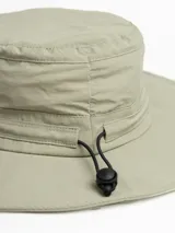 Gorro de pesca o safari color verde claro, con ala ancha y correa ajustable con tope. Presenta un pequeño bordado de una montaña en la parte frontal.
