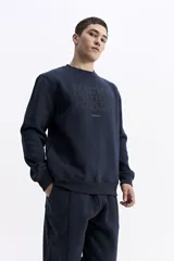 Buzo de algodón color marrón chocolate, con cuello redondo, mangas largas y estampa frontal con el nombre de la marca repetido en tono sobre tono.