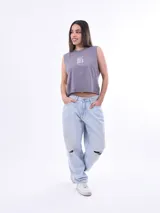 Remera sin mangas, color rosa claro, con cuello redondo y dobladillo inferior con terminación deshilachada. Presenta un pequeño estampado de trébol de cuatro hojas en color verde menta con texto debajo.