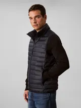 Chaleco acolchado tipo puffer de Calvin Klein, con cuello alto, cierre frontal con cremallera y diseño sin mangas.