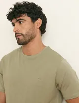Remera básica de algodón color beige, de manga corta, con cuello redondo y un pequeño detalle bordado en el pecho.