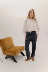 Pantalón tipo sastrero color gris oscuro, con pinzas delanteras, bolsillos laterales y traseros tipo vivo. De tiro medio, con botón dorado en la cintura.