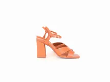 Sandalias de cuero color caramelo, con tiras cruzadas en el empeine, taco ancho alto y pulsera ajustable al tobillo con hebilla metálica.
