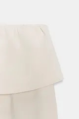 Pantalón de algodón compacto color beige, de tiro alto con cintura elástica y detalle de fajín y cordones.