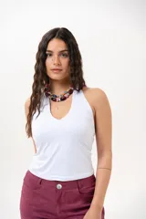 Top blanco básico de corte al cuerpo, con escote halter pronunciado en V y espalda semi descubierta.