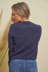 Saco de punto color azul marino, con cuello redondo y detalles de strass en el escote. Cierre frontal con botones de strass.