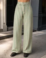 Pantalón de corte sastre y pierna ancha con diseño de rayas verticales en tonos verde, blanco y marrón, con tiro alto y trabillas para cinto.