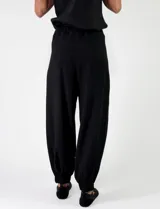Pantalon negro de viscosa con pinzas en la cintura, bolsillos laterales y botamangas ajustadas.