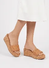 Sandalia de plataforma de corcho con capellada de cuero vacuno en tono tostado con diseño tejido.