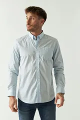 Camisa celeste de manga larga con logo bordado y bolsillo en el pecho.