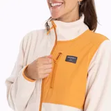 Campera polar color crema con paneles color naranja en la parte superior delantera y en el cuello. Cierre frontal con cremallera color naranja y bolsillos laterales con cierre.