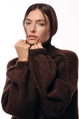 Sweater de punto grueso con cuello alto, diseño de hombros caídos y mangas amplias con puños acanalados.