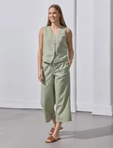 Chaleco de lino a rayas verticales blancas y grises, con escote en V, cierre frontal con botones y bolsillos simulados. Marca Alex & Jordan.