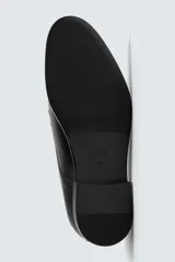 Zapato de vestir estilo Derby color marrón, fabricado en piel con horma redonda, cordones finos y suela con ligero tacón.