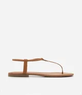 Sandalia plana de mujer color dorado metalizado, con diseño minimalista de tira fina que une la puntera y el empeine, y tira elástica fina alrededor del tobillo.