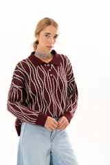 Buzo de punto color vino con diseño de rayas verticales irregulares en tonos claros. Presenta cuello polo con cierre frontal de tres botones, mangas largas con puños acanalados y corte holgado.