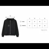 Campera con capucha y cierre frontal completo, color negro, con diseño oversize. Presenta bordado minimalista con la palabra GAINS en el pecho y detalle de texto en la manga.