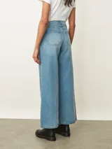 Jean de corte wide leg en color negro, con cintura alta ajustable mediante lazo y costuras verticales decorativas en el frente.