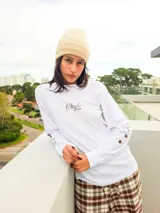Remera de manga larga color blanco, con estampado frontal con la frase 'Style Club' y estrellas pequeñas en las mangas.