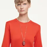 Colgante con dije en forma de fresa, elaborado con cristales en tonos rojos y detalles de cristales en tono dorado que representan las semillas, con baño en tono oro.