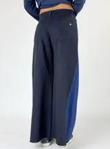 Pantalón de denim gris oscuro con paneles laterales en color bordó y corte acampanado.