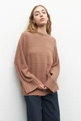 Sweater color marrón claro con cuello redondo y mangas largas acampanadas.