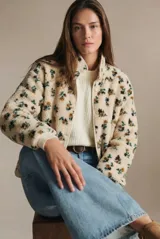 Campera de corderito con estampado floral, cuello alto y cierre frontal con botones a presión. Posee puños elásticos y un diseño de ajuste al cuerpo.