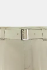 Pantalón cargo de tiro medio confeccionado en tejido satinado color beige, de corte recto y holgado. Cuenta con bolsillos laterales con solapa, bolsillos frontales y un cinturón integrado del mismo tejido con hebilla metálica.