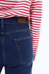 Jean de corte recto y tiro medio, confeccionado en denim negro con efecto lavado. Presenta cierre frontal con botón y bolsillos laterales.