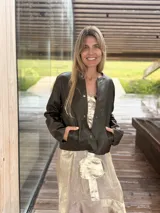 Campera corta de cuero ovino color verde militar, con cuello redondo, cierre frontal con botones a presión y bolsillos laterales ojal.